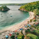 Beautiful sunset view over the ocean and palm trees at Crystal Bay Beach in Nusa Penida