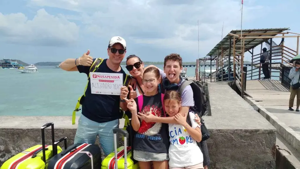 Happy family arriving at harbour with luggage using Nusa Penida Transport private driver and local guide service.