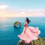 Panoramic view of towering white limestone cliffs and a rock arch in the ocean at Banah Cliff Nusa Penida.