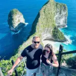 The Ultimate Nusa Penida Tour: Experience Bali’s Hidden Paradise with Local Experts 17 A tourist couple taking a photo at the Kelingking Beach cliff while joining a Nusa Penida Tour with NPT.